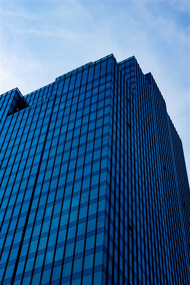 Blue glass skyscraper rising above the city